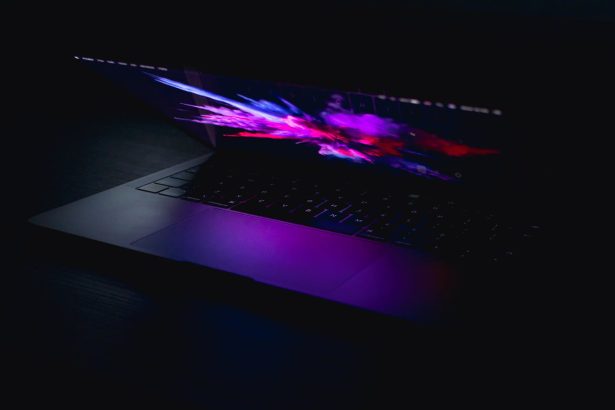 A laptop displaying a vibrant abstract design in low light, highlighting artistic and digital design concepts.